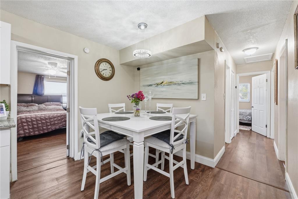 A dining area with a white table and chairs sits between two bedroom doorways — 1410 KOZART COURT, ORLANDO, FL
