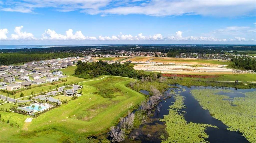 An aerial view shows a residential neighborhood with a swimming pool next to a lake — 2926 BLACK BIRCH DRIVE, OCOEE, FL