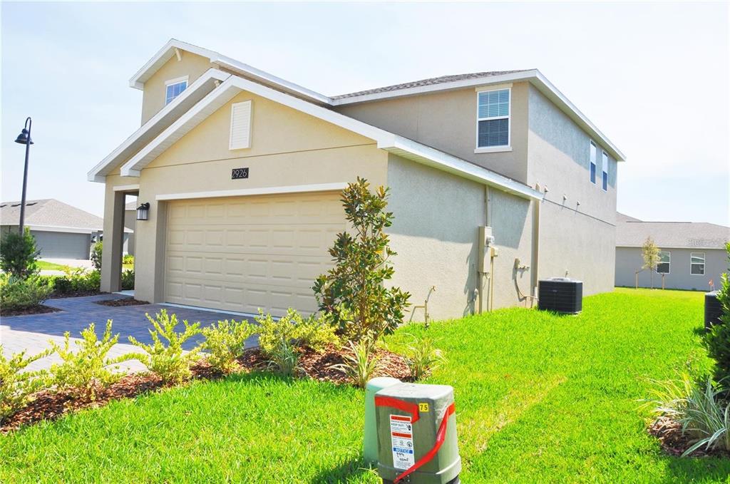 A two-story suburban house with a tan stucco exterior and a two-car garage — 2926 BLACK BIRCH DRIVE, OCOEE, FL