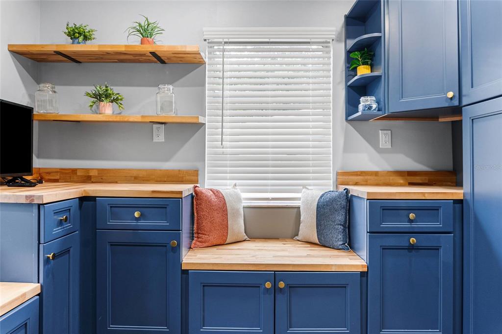 A kitchen features blue cabinets, wood countertops, open shelving, and a window seat — 3761 N HIAWATHA TER, CRYSTAL RIVER, FL