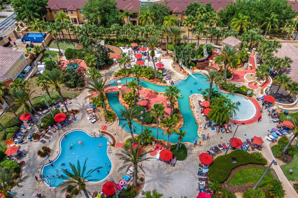 An aerial view of a resort pool area with a lazy river and lounge chairs — 245 CAMBRIA AVENUE, DAVENPORT, FL