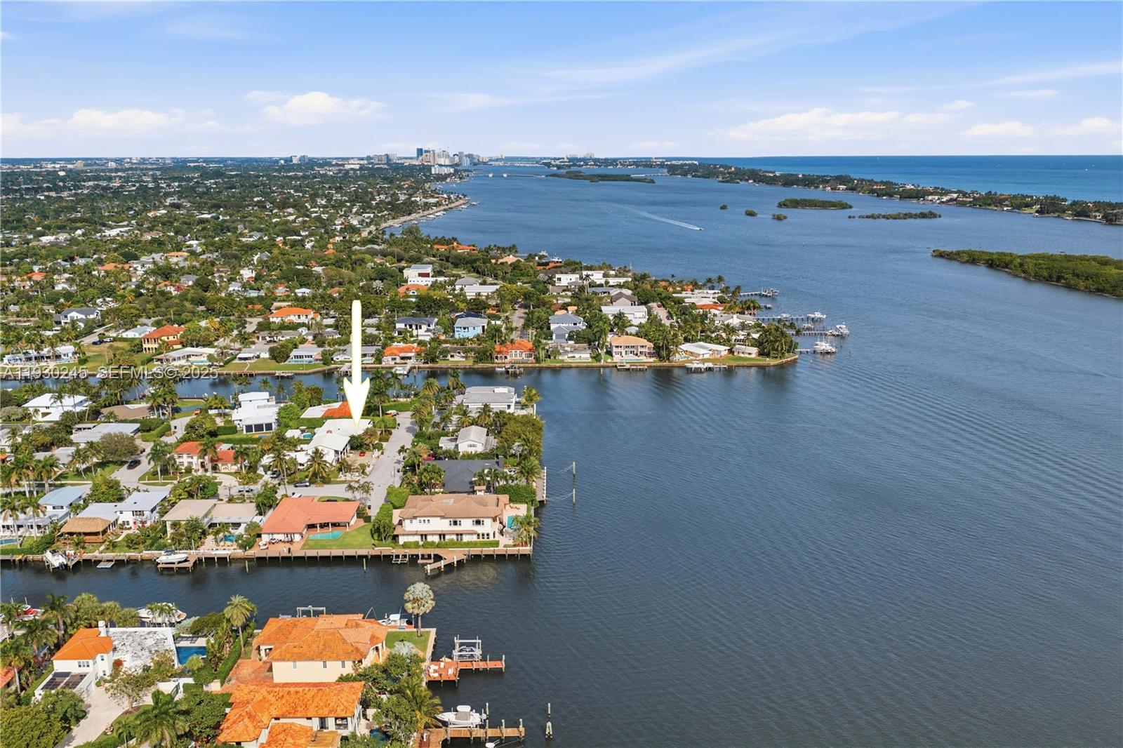 An aerial view shows a waterfront residential neighborhood with a house marked by an arrow — 2607 Holy Cross Ln, Lake Worth FL 33460, LAKE WORTH, FL