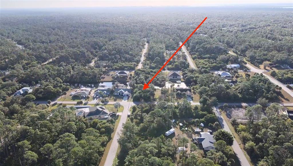 An aerial view shows a wooded residential lot marked by a red arrow — 468 CORY STREET, PORT CHARLOTTE, FL