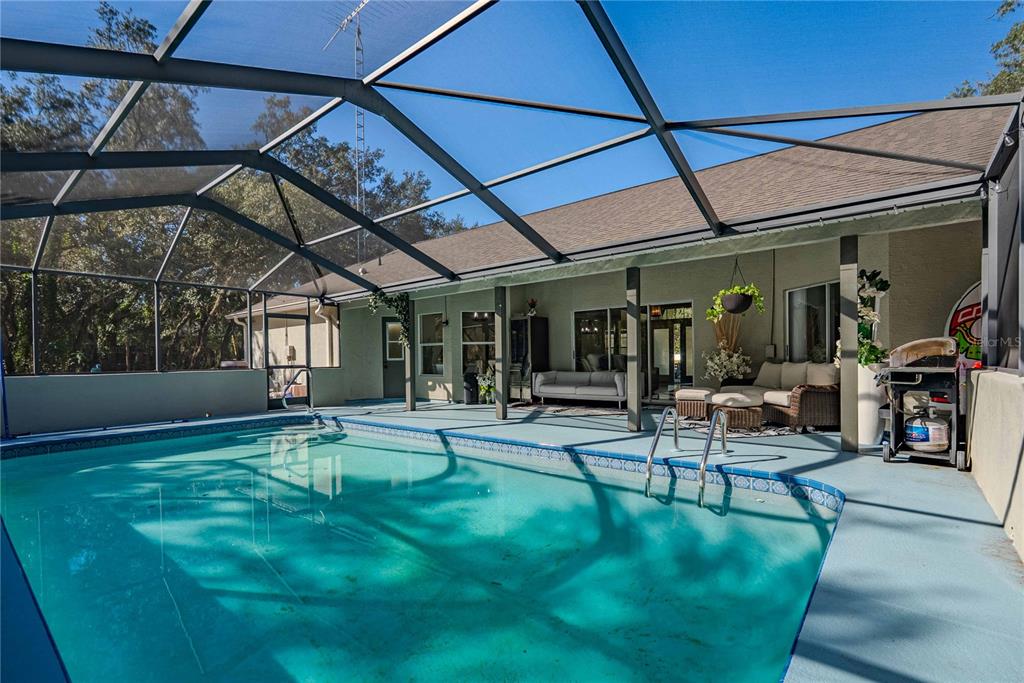A concrete walkway leads to the front entrance of a house with two white columns — 14214 CINNAMAN LANE, WEEKI WACHEE, FL