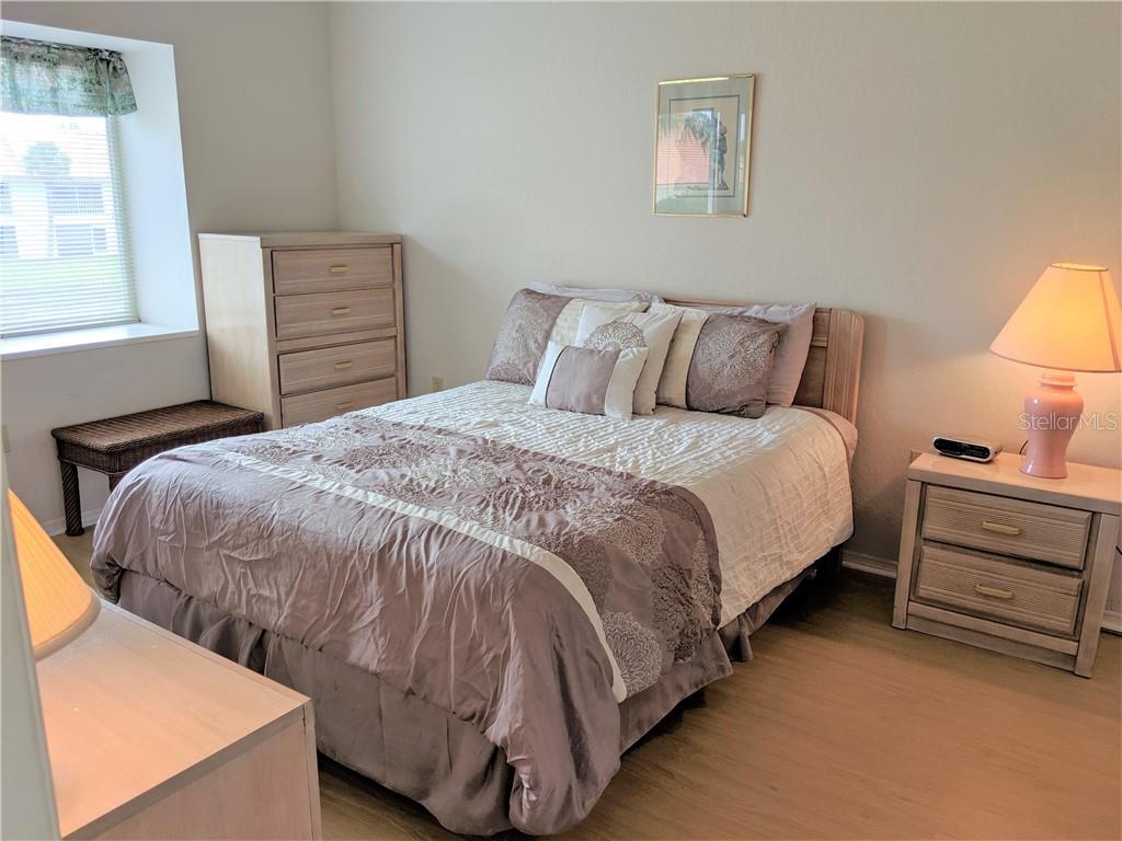 A bedroom features a bed with mauve bedding, a dresser, a nightstand, and a window — 4378 MADERIA COURT COURT UNIT n/a, SARASOTA, FL