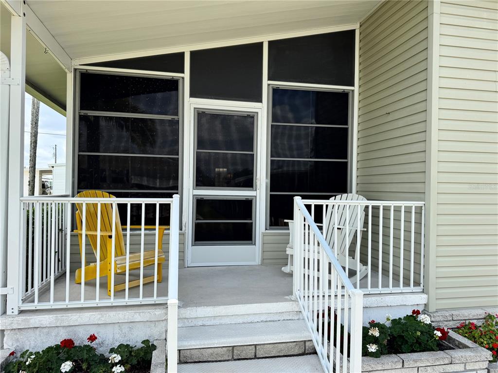 A covered porch features a screen door, two chairs, and a white railing — 346 ANDROS DRIVE, SARASOTA, FL