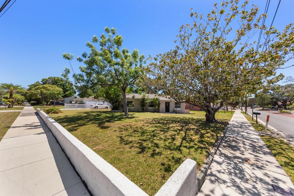 A single-story house with a large front yard and two mature trees sits on a corner — 1135 FAIRMONT STREET, CLEARWATER, FL