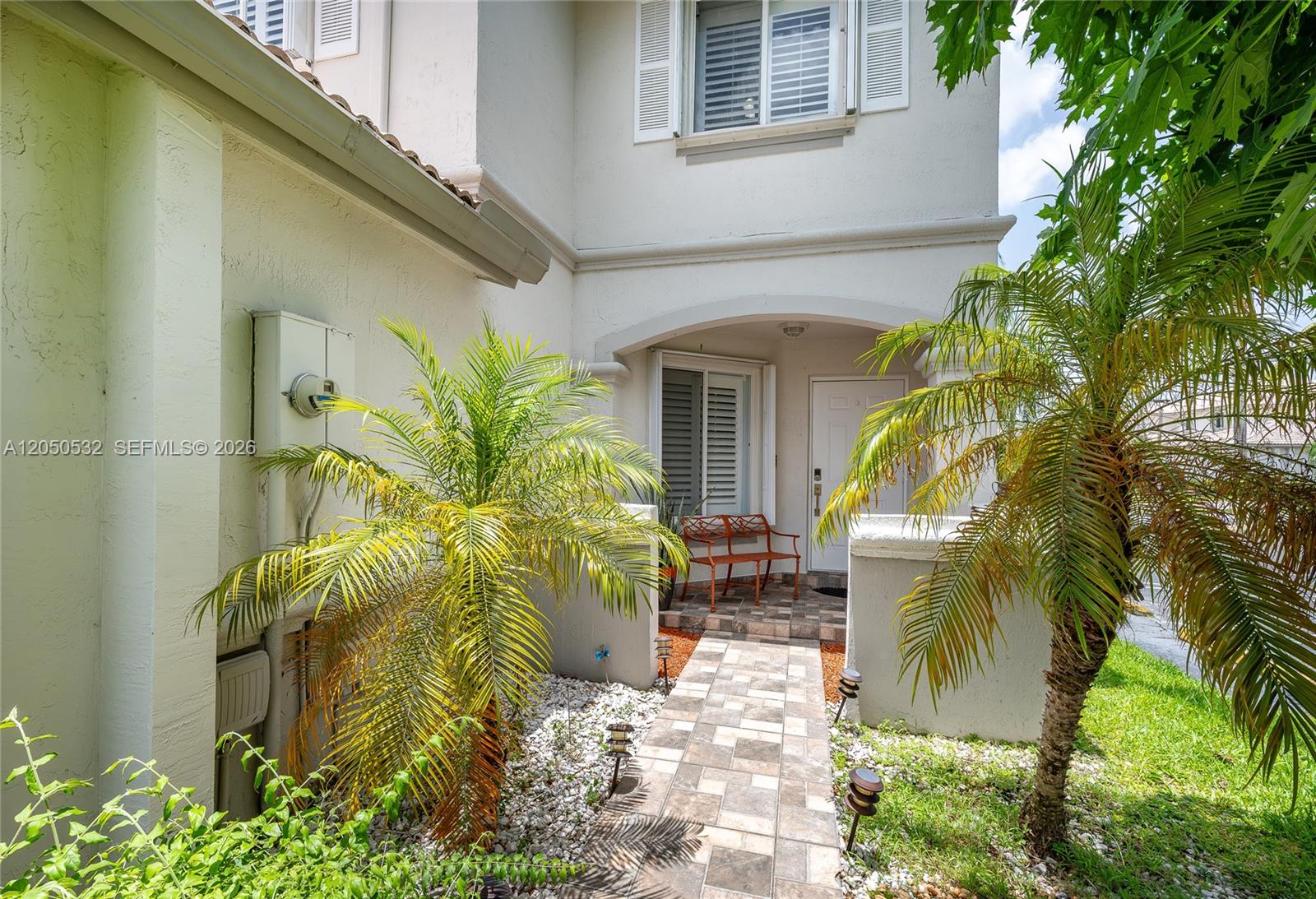 A tiled walkway leads to the front entrance of a two-story home with palm trees — 7240 SW 162nd Ct, Miami FL 33193, MIAMI, FL