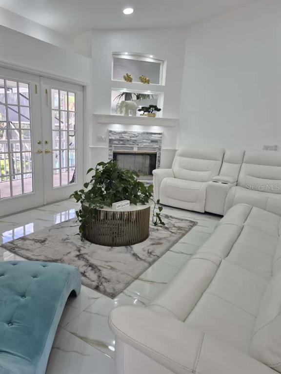 A living room features white leather sofas, a fireplace, and a circular coffee table — 5451 TROPIC DRIVE, NEW PORT RICHEY, FL