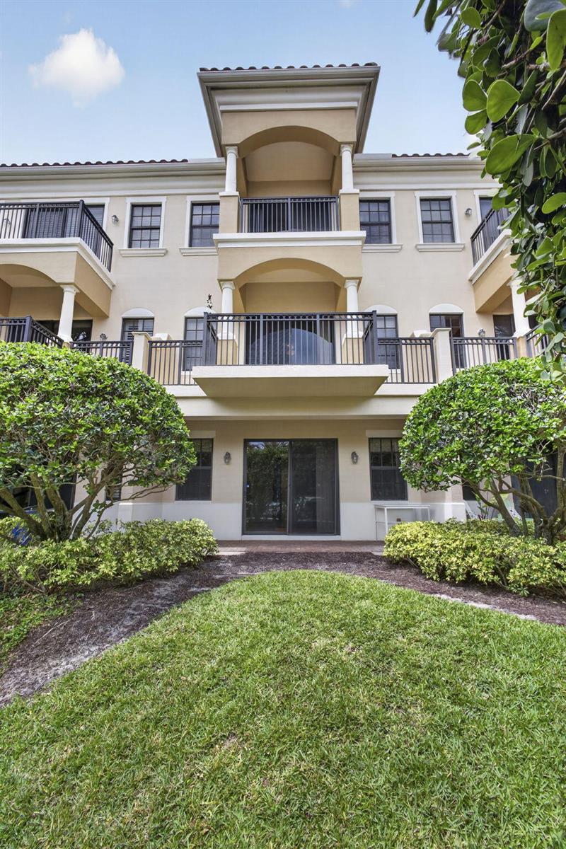 A three-story apartment building features balconies, sliding glass doors, and manicured landscaping in front — 803 Del Sol Circle, Tequesta FL 33469, TEQUESTA, FL