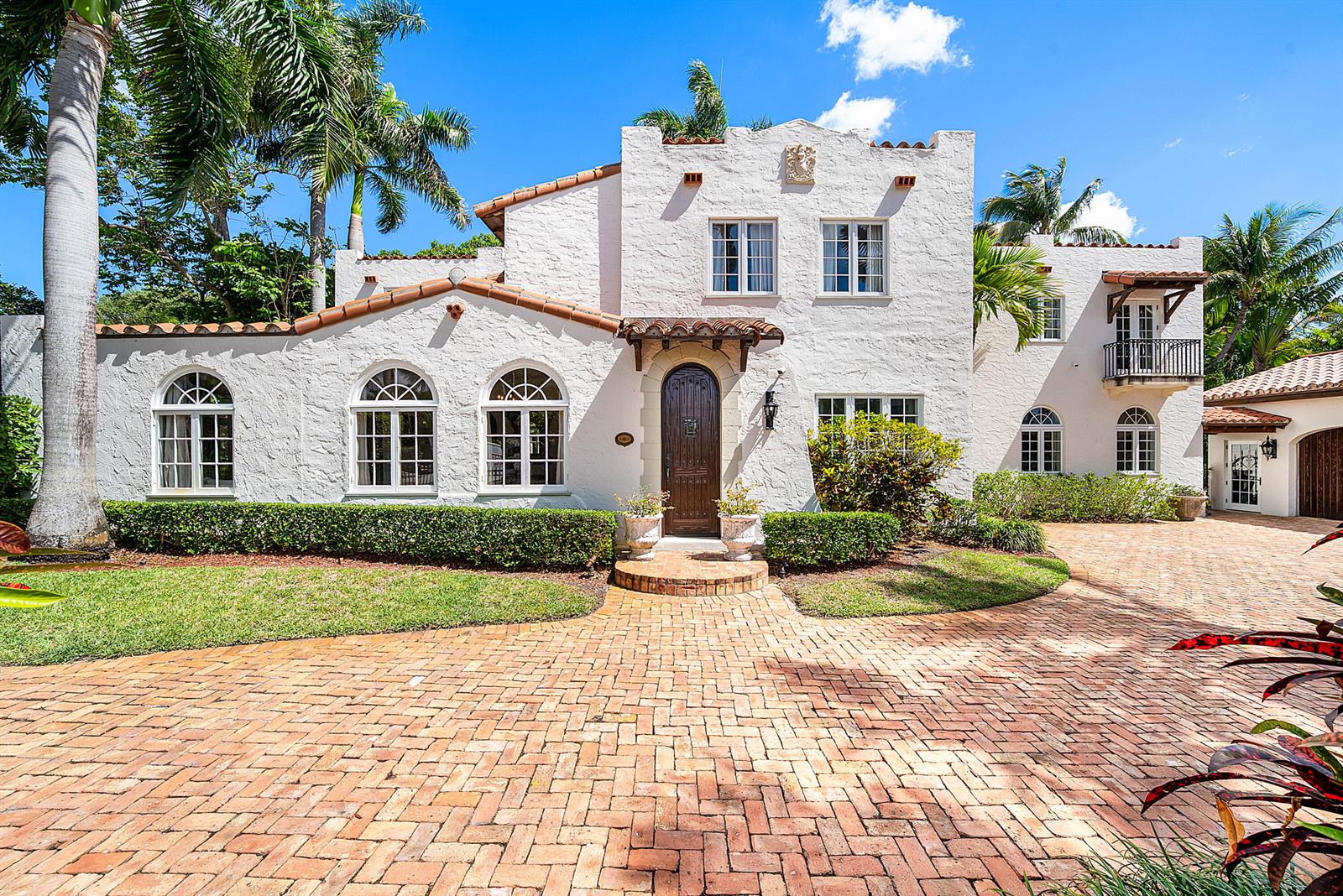 A white stucco house with a brick driveway and arched windows under a blue sky — 255 Cordova Road, West Palm Beach FL 33401, WEST PALM BEACH, FL