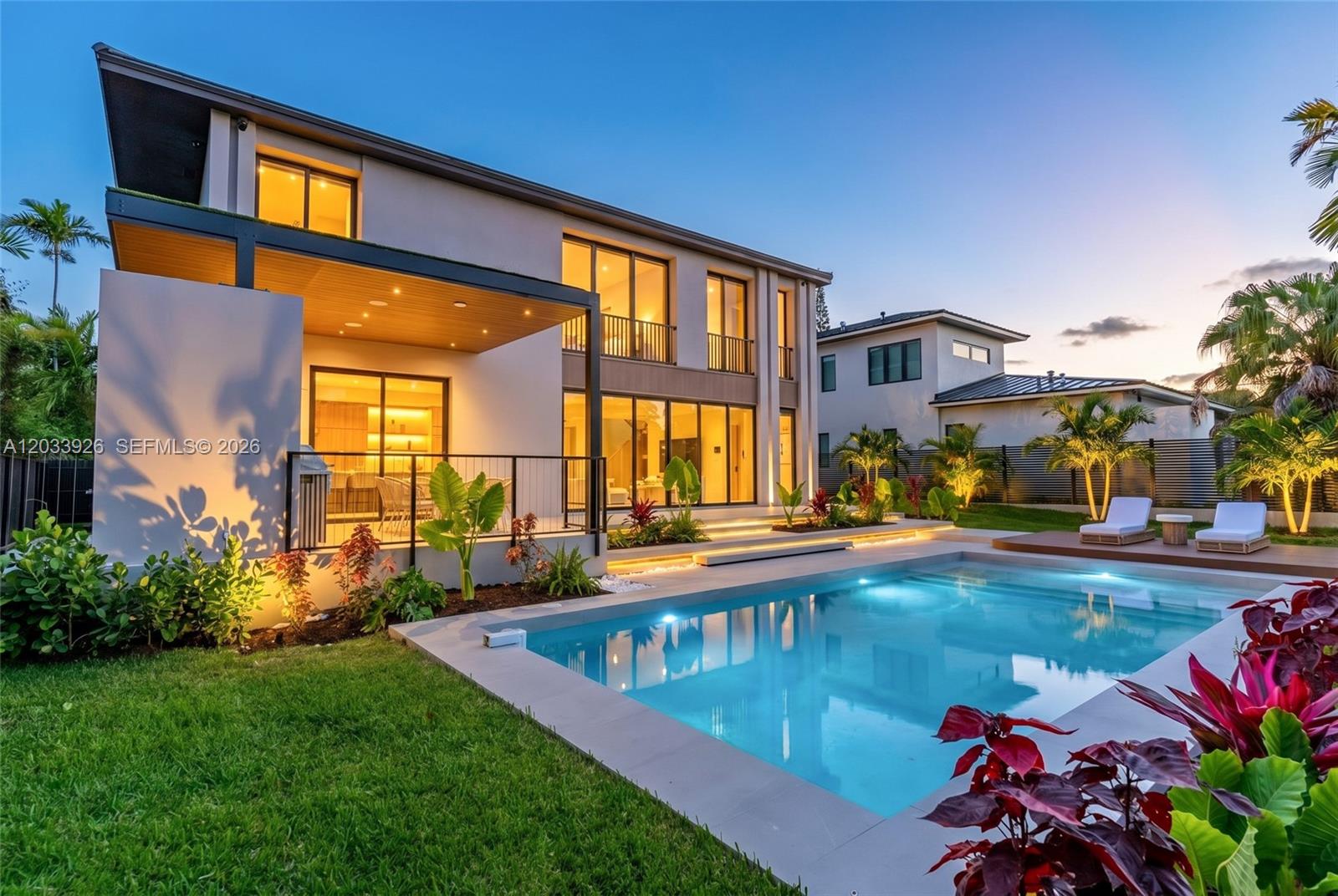 A modern two-story house features a swimming pool, patio, and landscaped yard at dusk — 5854 SW 30th St, Miami FL 33155, MIAMI, FL