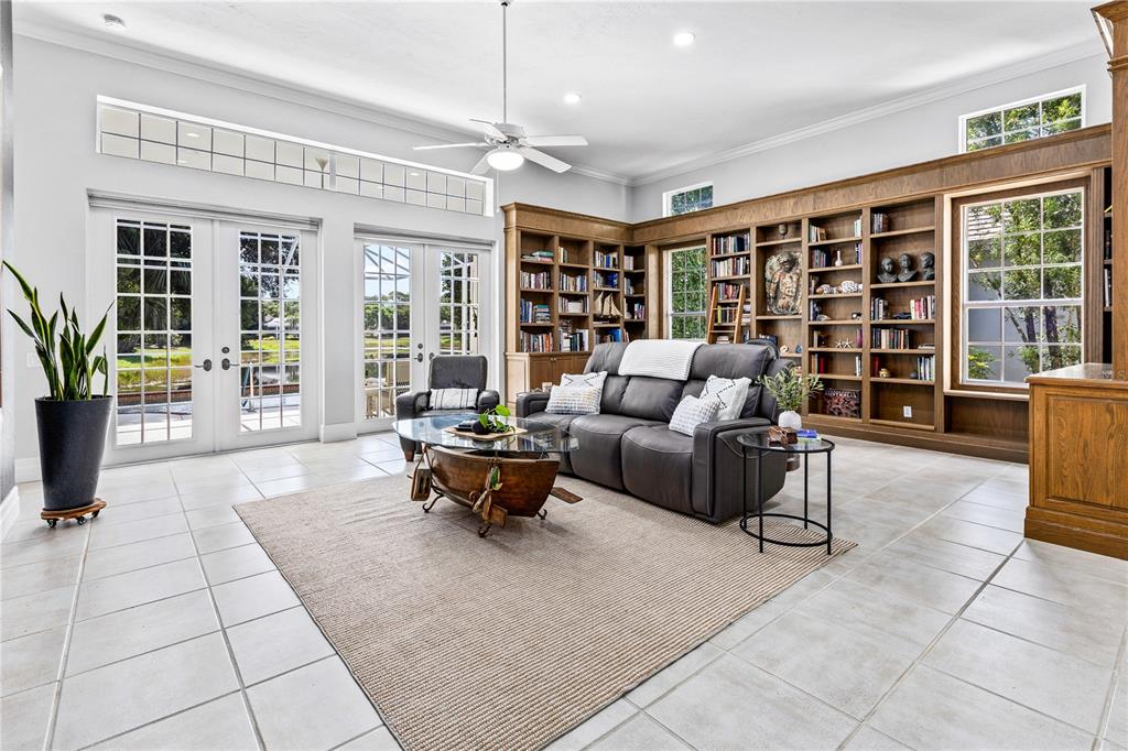 A white kitchen features a large stone-topped island, stainless steel appliances, and wood-look flooring — 7105 VICTORIA CIRCLE, BRADENTON, FL