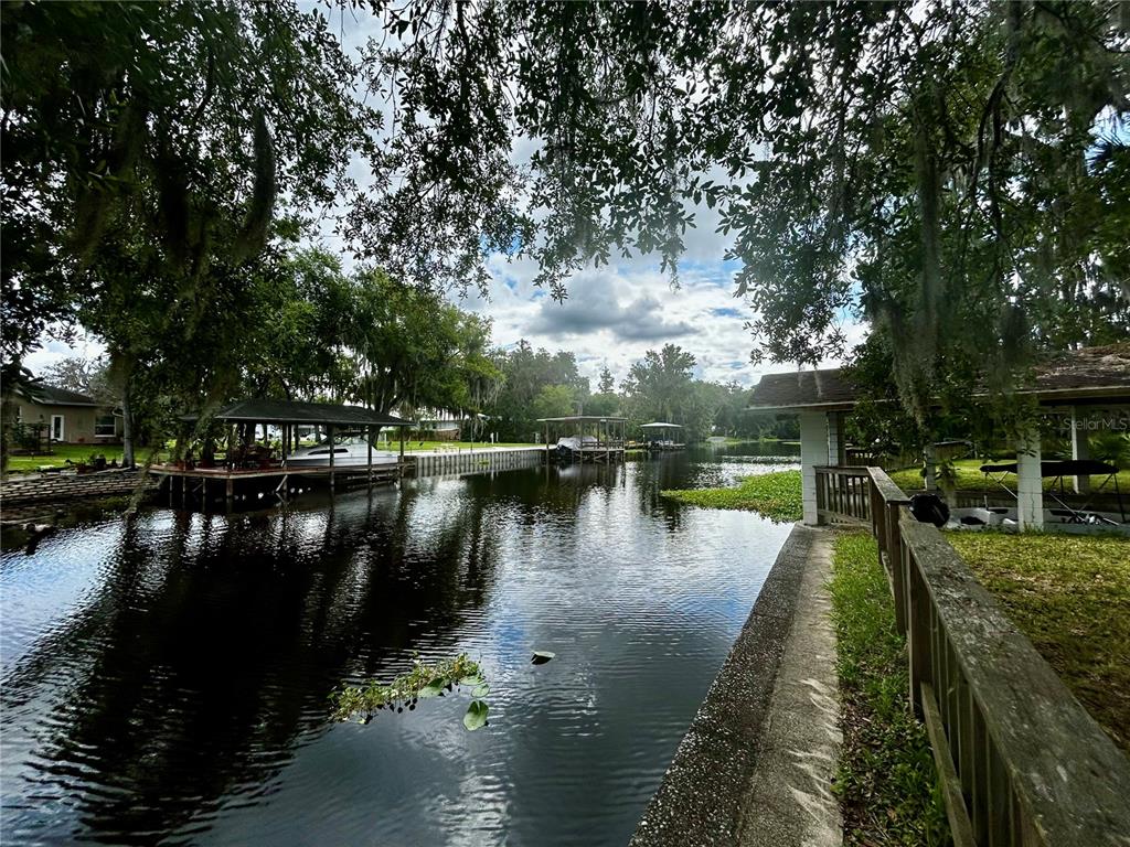 A canal view featuring boat docks and lush trees along the waterfront — 2950 N SHELL ROAD, DELAND, FL