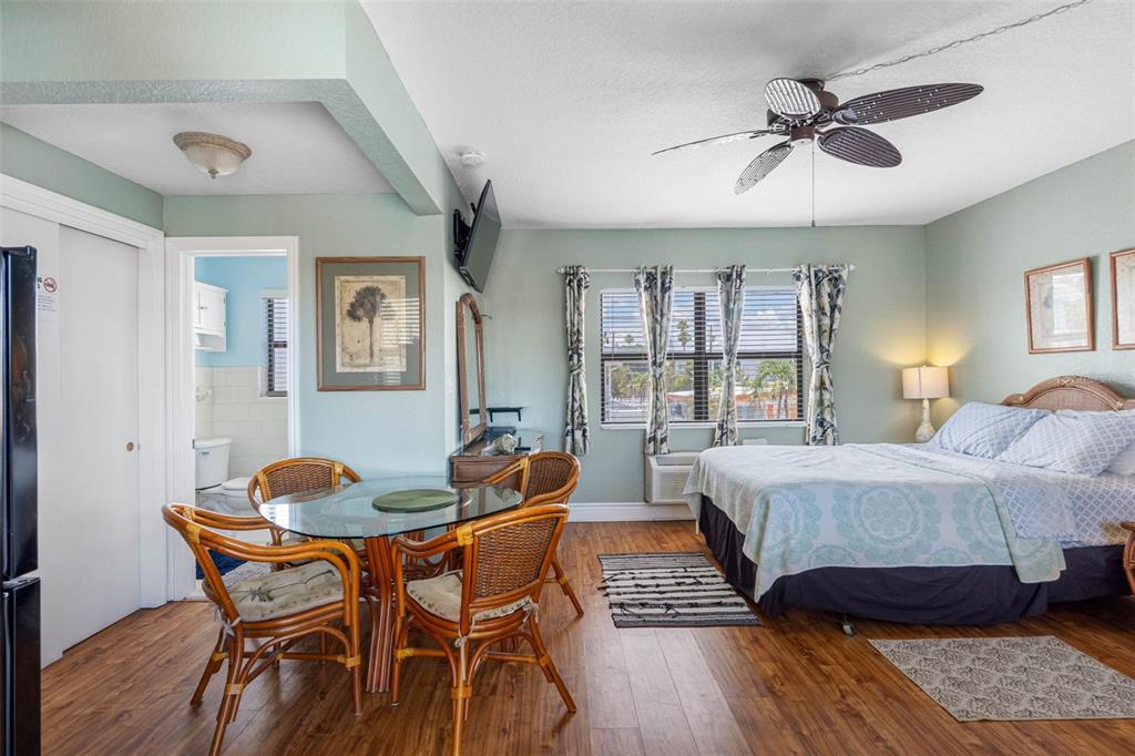 A hotel room features a dining table, a bed, and an attached bathroom — 16333 GULF BOULEVARD UNIT 210, ST PETERSBURG, FL