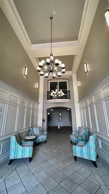 A formal lobby features a high ceiling, two chandeliers, tiled flooring, and four patterned chairs — 4804 CAYVIEW AVENUE UNIT 20412, ORLANDO, FL