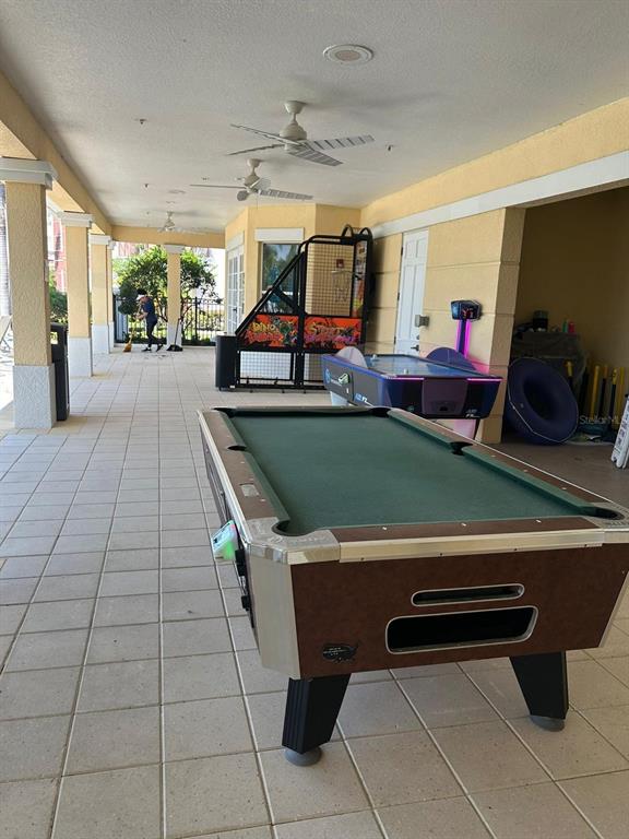 A covered outdoor patio features a pool table, air hockey table, and arcade game — 4804 CAYVIEW AVENUE UNIT 20412, ORLANDO, FL