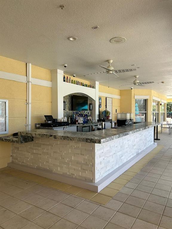 An outdoor bar features a stone-tiled base, granite countertop, and two ceiling fans — 4804 CAYVIEW AVENUE UNIT 20412, ORLANDO, FL