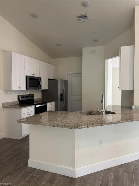 A kitchen features white cabinets, granite countertops, stainless steel appliances, and a breakfast bar — 2614 27th ST W, Lehigh Acres FL 33971, LEHIGH ACRES, FL