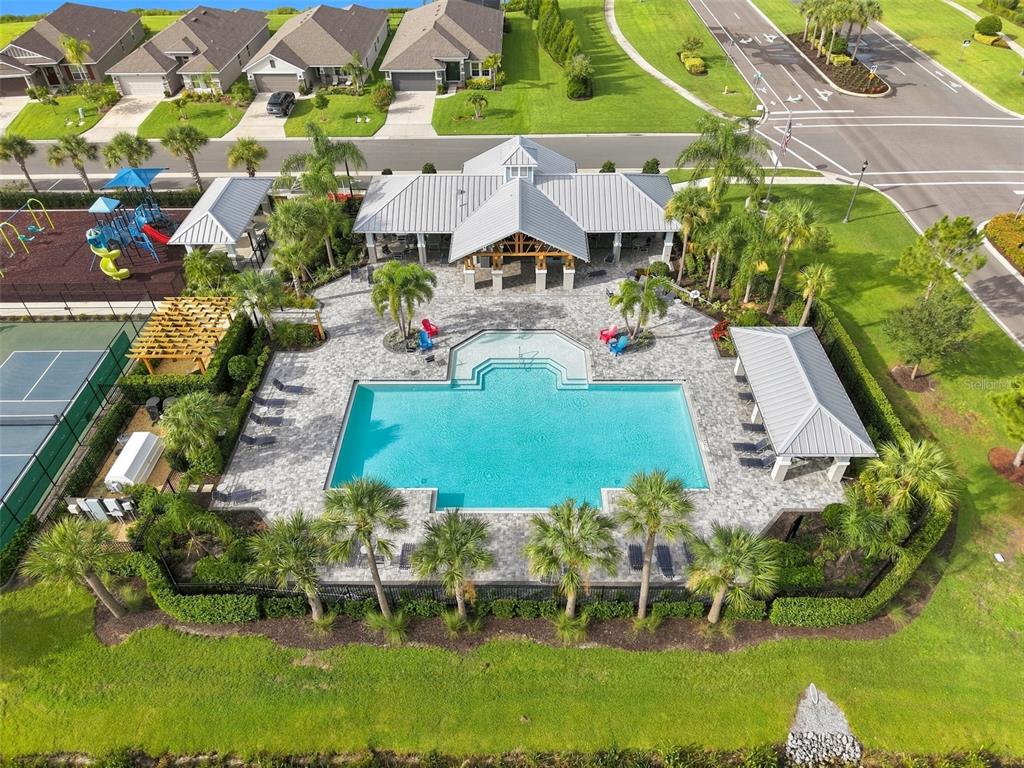 An aerial view shows a community swimming pool, a playground, and a clubhouse with walkways — 16331 66TH LANE E, PARRISH, FL
