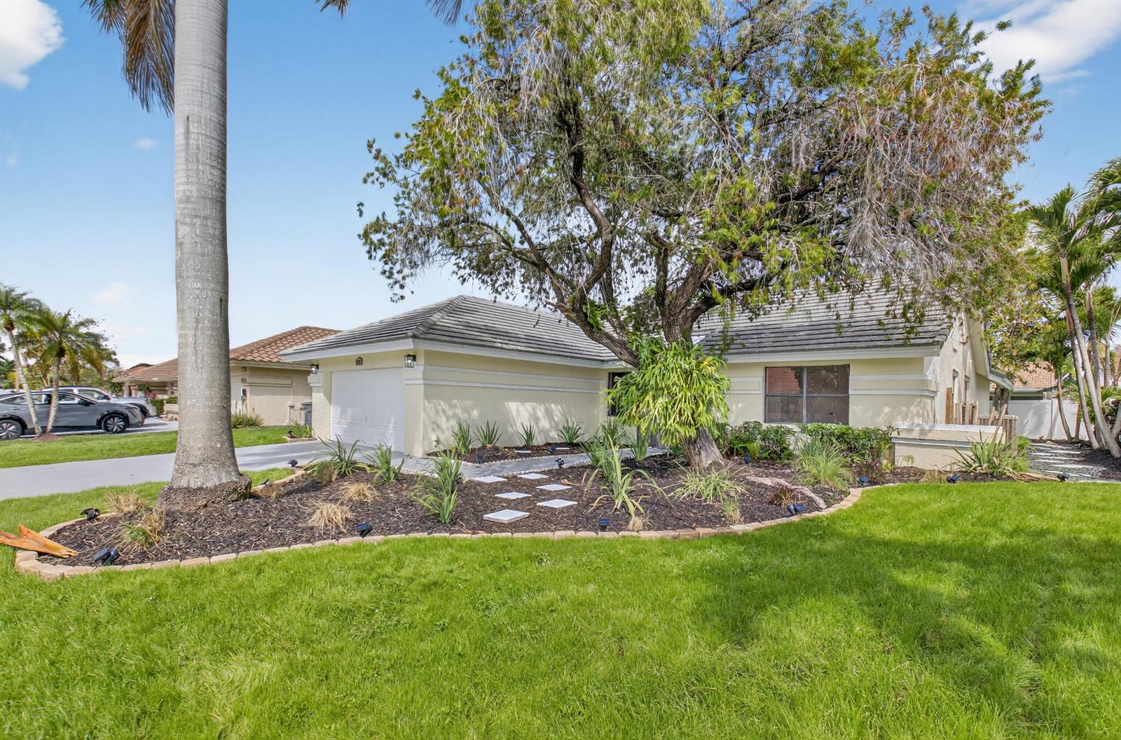 A single-story house with a white garage, a large tree, and a landscaped front yard — 9537 Majestic Way, Boynton Beach FL 33437, BOYNTON BEACH, FL