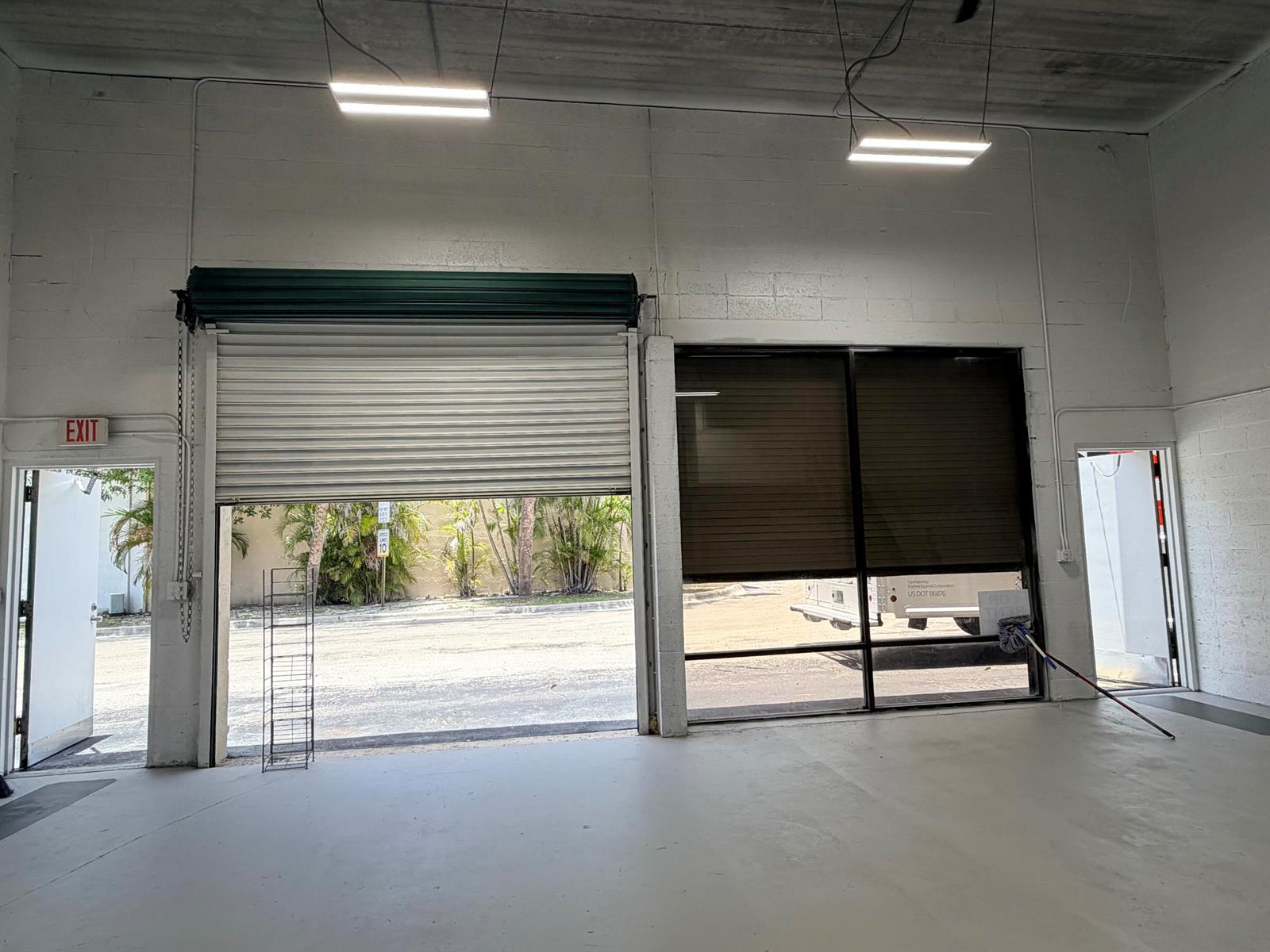 An industrial warehouse space features a roll-up door, large windows, and two exit doors — 1791 Blount Road # 922, Pompano Beach FL 33069, POMPANO BEACH, FL