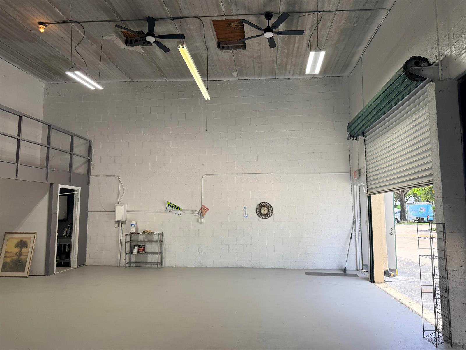 An empty industrial warehouse space with white cinder block walls, concrete floors, and ceiling fans — 1791 Blount Road # 922, Pompano Beach FL 33069, POMPANO BEACH, FL