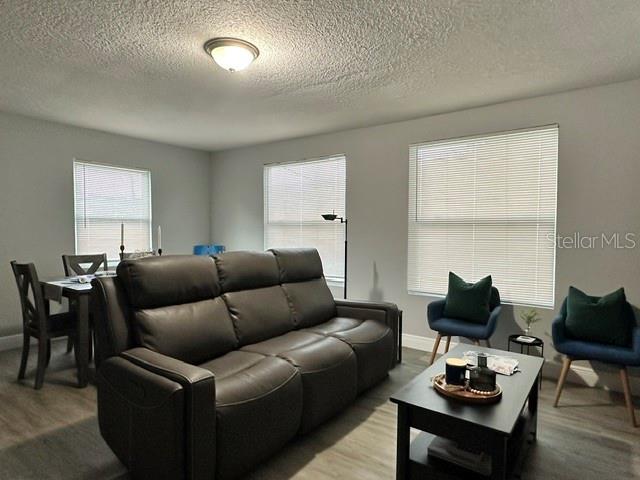 A living room features a brown leather sofa, a coffee table, and a dining area — 438 S HUDSON STREET, ORLANDO, FL