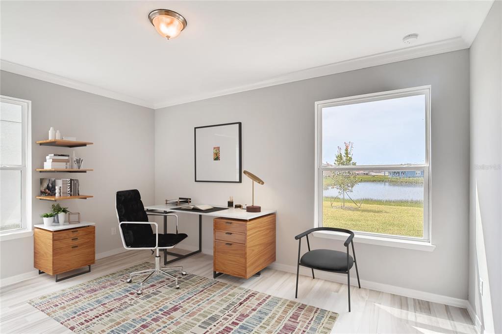 A home office features a desk, two chairs, wall shelving, and a window overlooking a pond — 5171 MOCKINGBIRD SOUND COURT, SANFORD, FL
