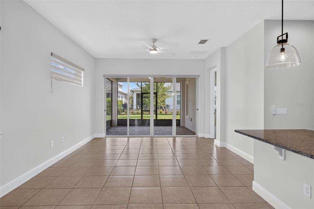 A dining area with tile flooring, a ceiling fan, and sliding glass doors to a patio — 2286 DATURA LOOP, ST CLOUD, FL