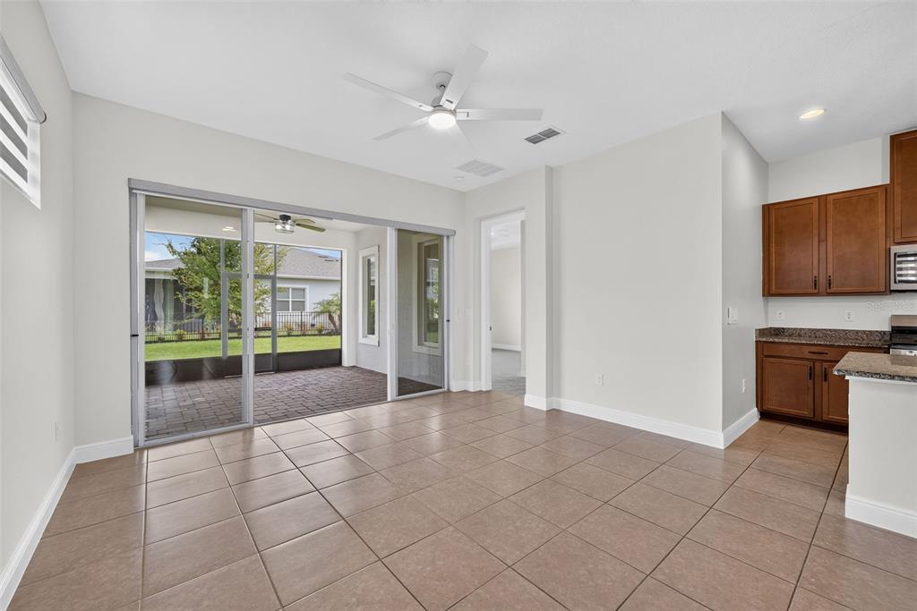 A tiled dining area features a ceiling fan and sliding glass doors leading to a patio — 2286 DATURA LOOP, ST CLOUD, FL