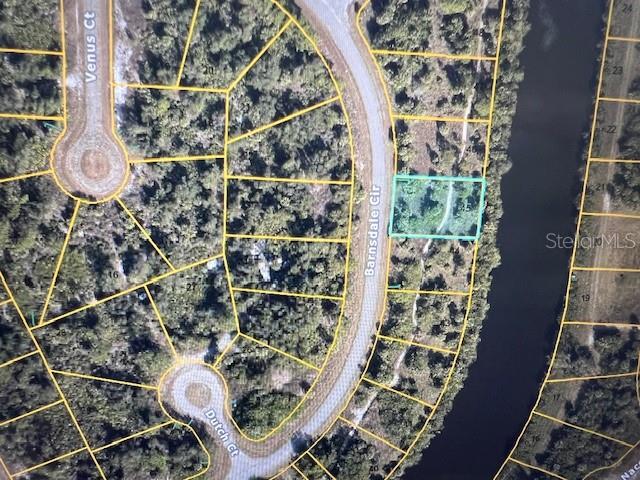 This is an aerial map showing a vacant lot highlighted in blue along a curved road — LOT 45 BARNSDALE CIRCLE, NORTH PORT, FL