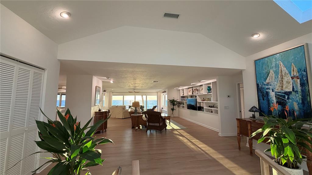 A spacious living room features vaulted ceilings, light wood floors, and a view of the ocean — 2709 CASEY KEY ROAD, NOKOMIS, FL