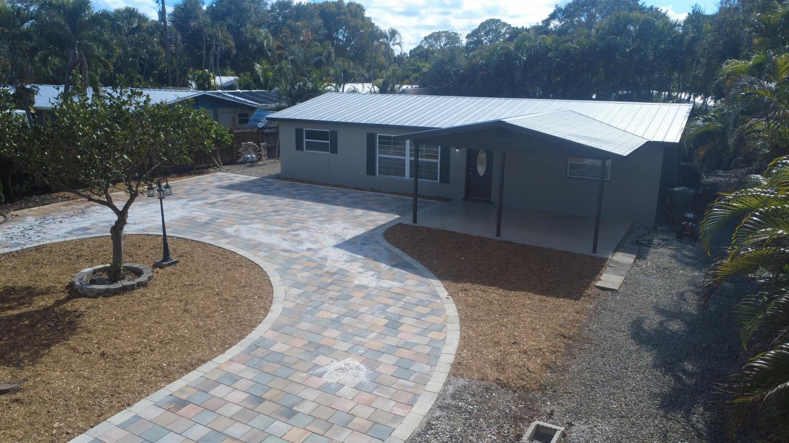 A single-story house with a metal roof and a newly installed paver driveway and walkway — 507 SW North River Point Drive, Stuart FL 34994, STUART, FL