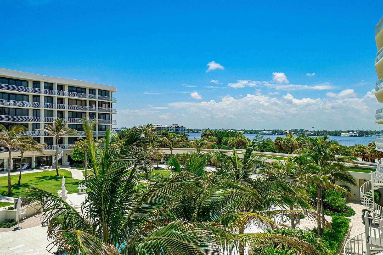An elevated view of a resort-style courtyard with palm trees, a pool, and waterfront scenery — 2000 S Ocean Boulevard # 208n, Palm Beach FL 33480, PALM BEACH, FL