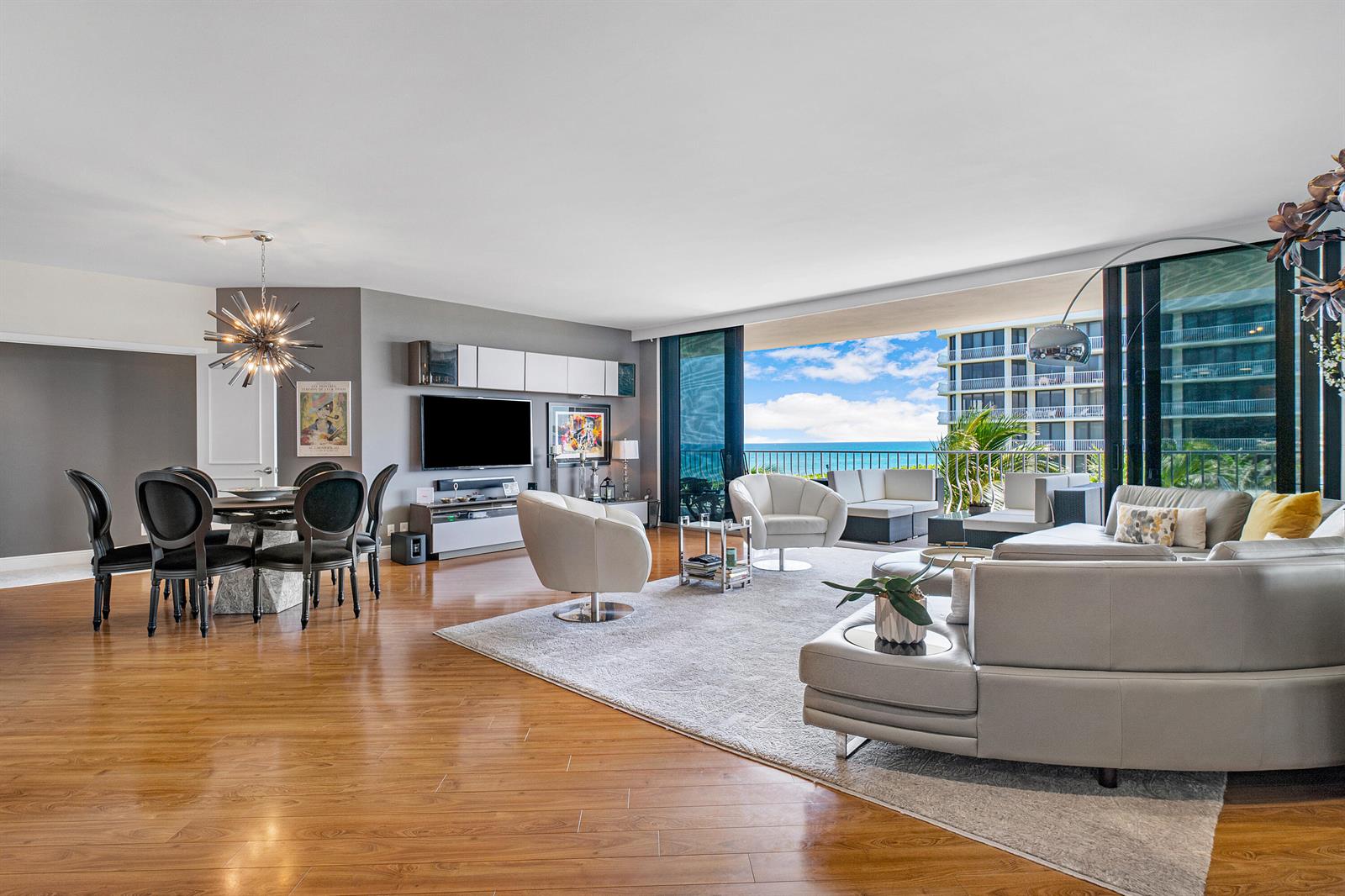 A spacious living and dining area features hardwood floors, modern furniture, and a balcony view — 2000 S Ocean Boulevard # 208n, Palm Beach FL 33480, PALM BEACH, FL