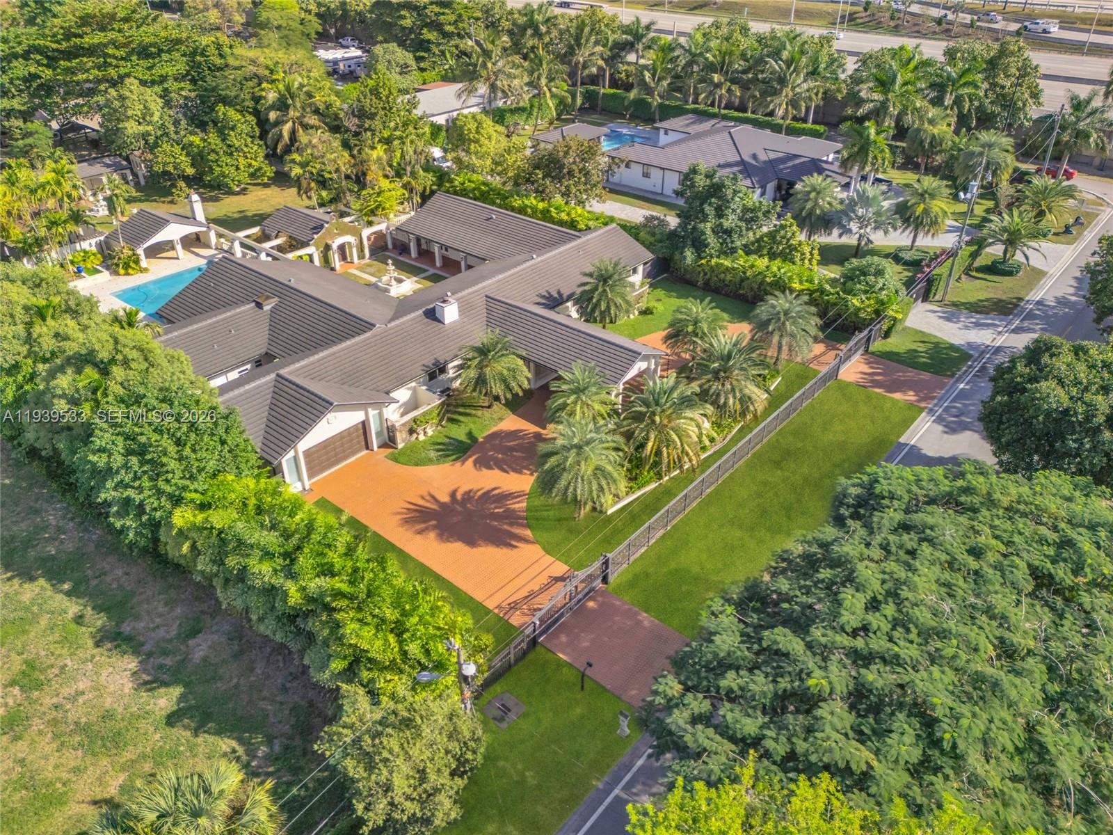 An aerial view shows a large house with a dark roof, pool, and paved driveway — 11835 SW 47th St, Miami FL 33175, MIAMI, FL