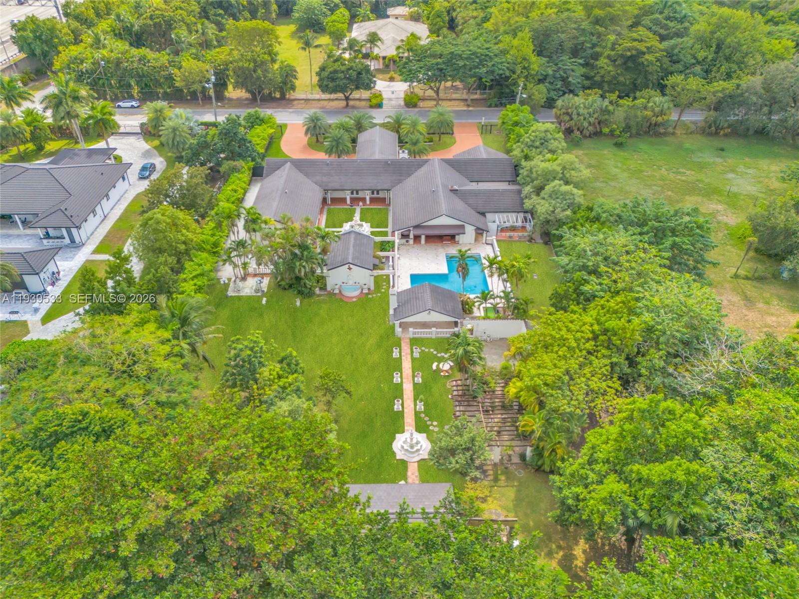 An aerial view shows a large house with a swimming pool, fountain, and expansive lawn — 11835 SW 47th St, Miami FL 33175, MIAMI, FL