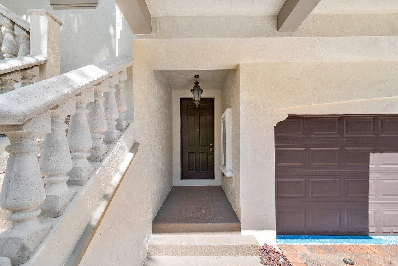 An exterior view shows a recessed front door, a stone staircase, and a garage door — 3018 Waterside Circle, Boynton Beach FL 33435, BOYNTON BEACH, FL