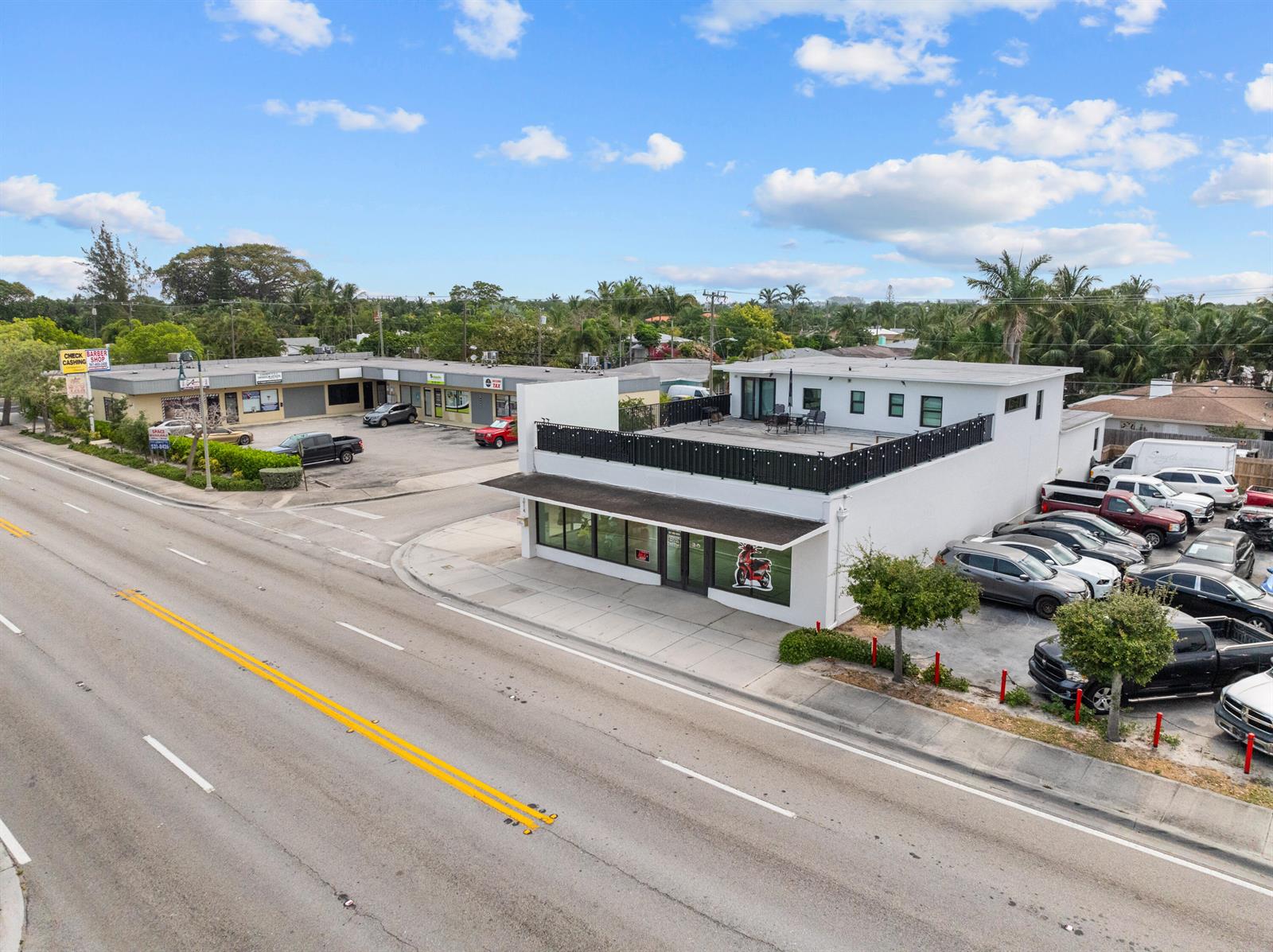 An aerial view shows a commercial building with a rooftop deck and adjacent parking lot — 1914 N Dixie Highway, FL 33460, FL