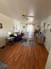 A living room features hardwood floors, a dark sofa, a ceiling fan, and a sliding door — 5906 17TH STREET W UNIT C35, BRADENTON, FL