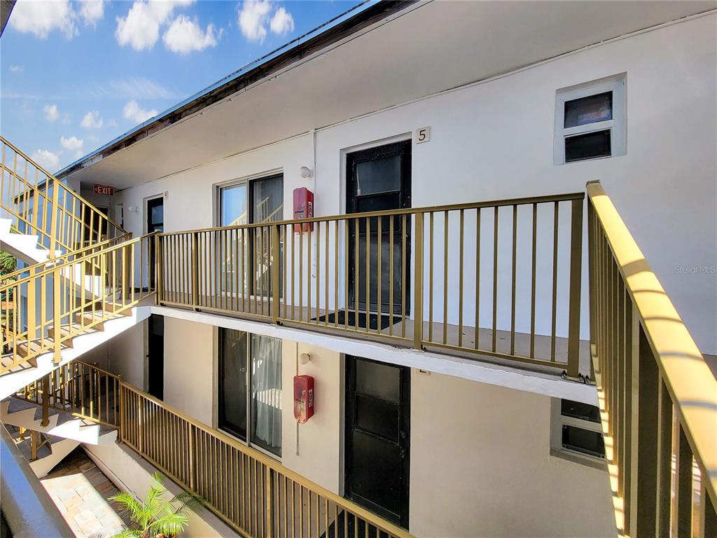 An exterior view of a two-story apartment building with metal railings and staircases — 404 HARRISON AVENUE, CAPE CANAVERAL, FL