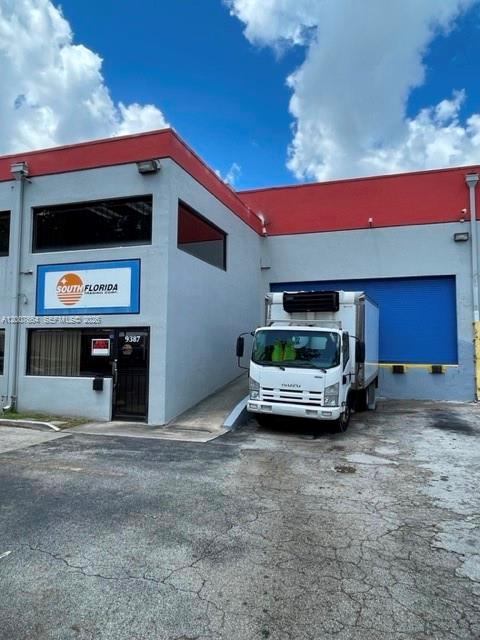 A white box truck is parked in front of a commercial building with red trim — 9387 NW 13th St # 7, Doral FL 33172, DORAL, FL