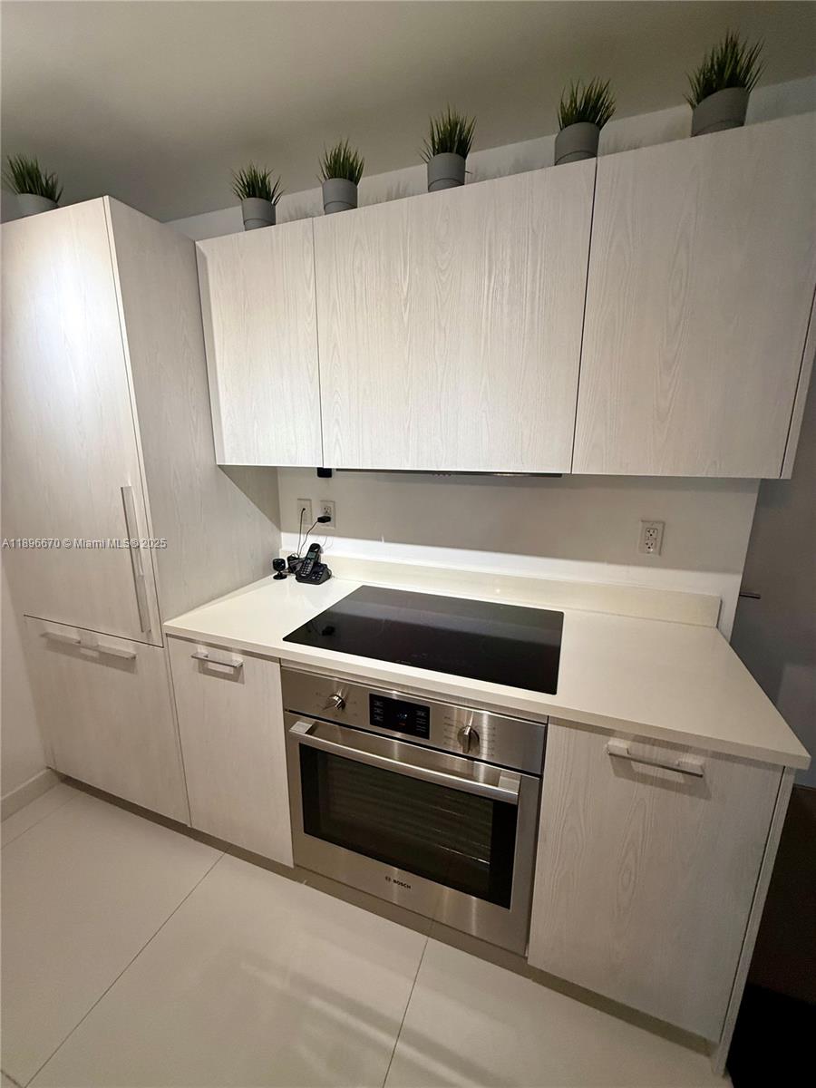 A kitchen features light wood-grain cabinets, a white countertop, and a stainless steel oven — 501 NE 31st St # 602, Miami FL 33137, MIAMI, FL