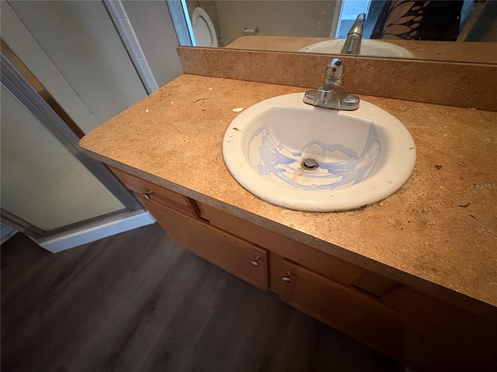 A bathroom vanity features a tan laminate countertop, a white sink, and wood cabinets — 13912 SW 61ST CIRCLE, OCALA, FL