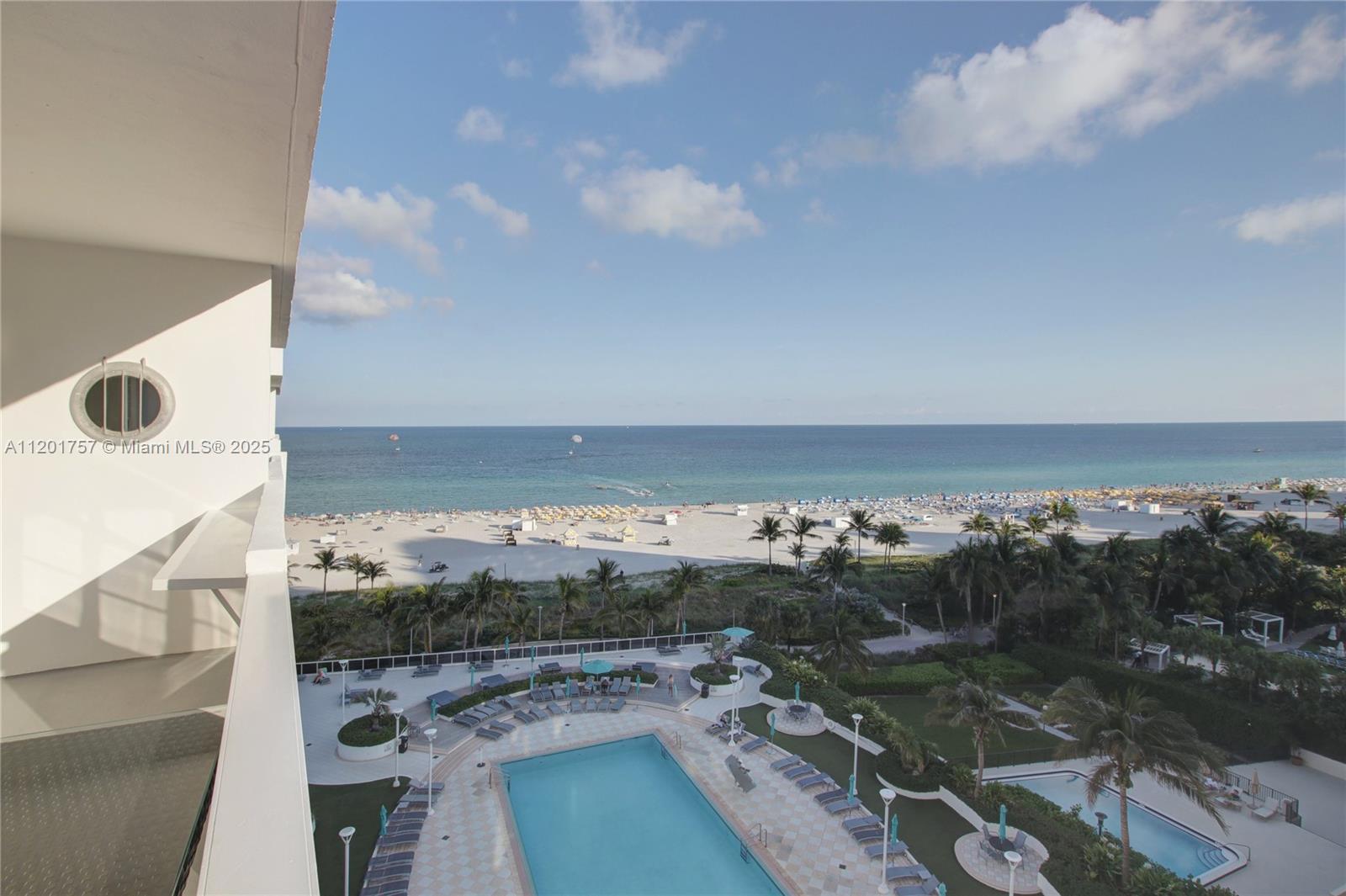 An elevated view shows a swimming pool deck overlooking a sandy beach and the ocean — 100 Lincoln Rd # 940, Miami Beach FL 33139, MIAMI BEACH, FL