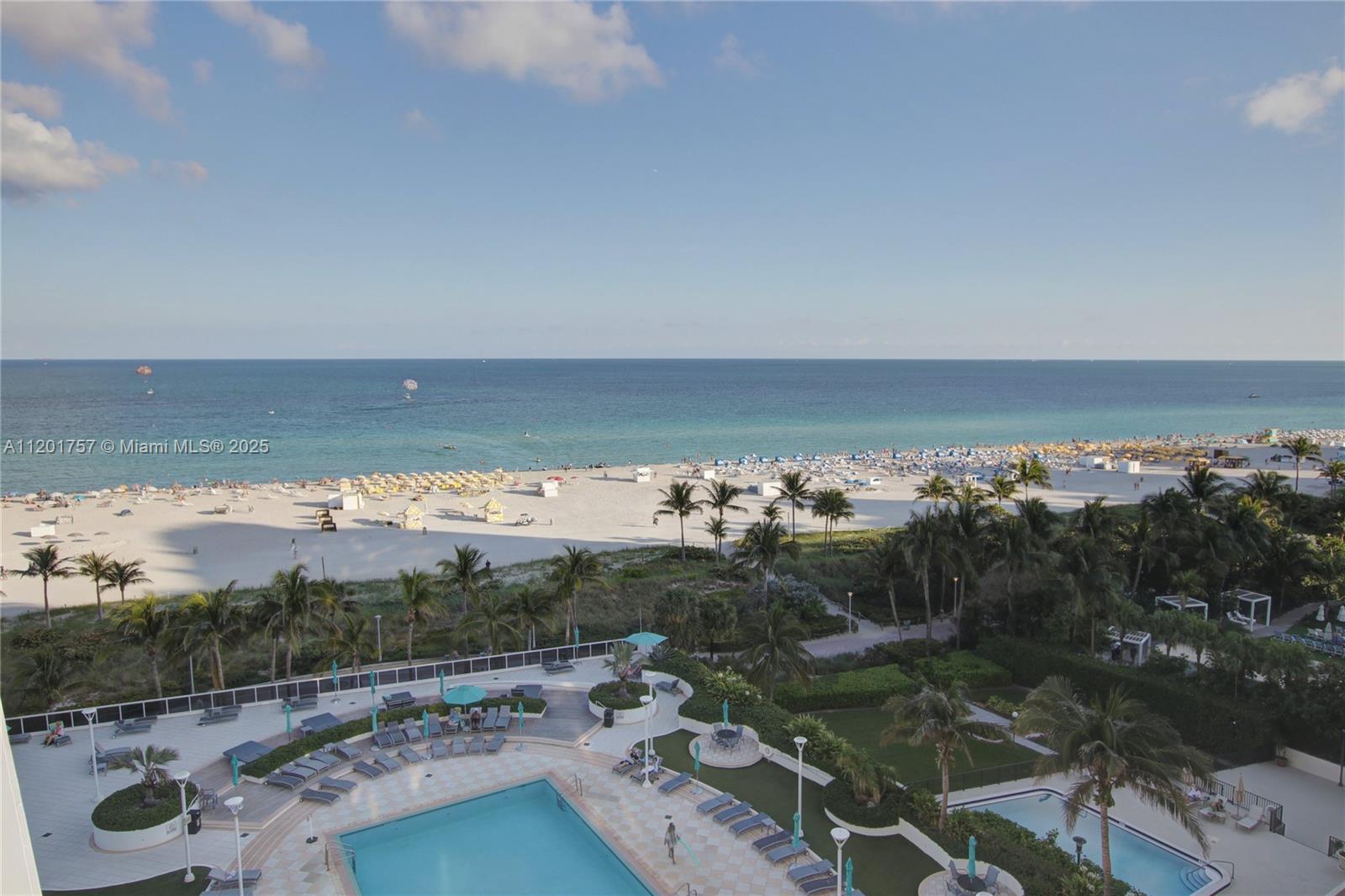 An elevated view shows a swimming pool deck overlooking a sandy beach and ocean — 100 Lincoln Rd # 940, Miami Beach FL 33139, MIAMI BEACH, FL
