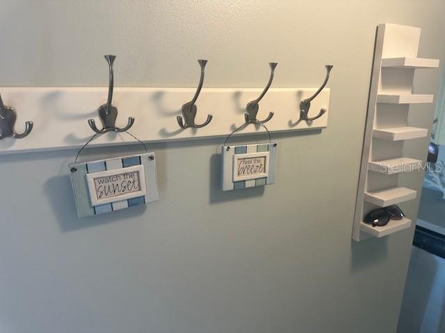 A wall-mounted coat rack with decorative signs and a vertical shelving unit on a wall — 17580 GULF BOULEVARD UNIT 403, REDINGTON SHORES, FL