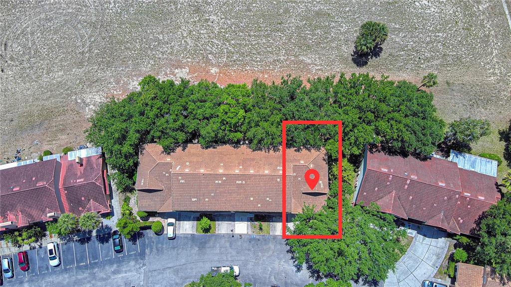 An aerial view shows a multi-unit residential building with a red tile roof and parking — 1236 N FAIRWAY DRIVE, APOPKA, FL