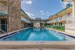 A rectangular swimming pool is situated between two levels of a residential apartment complex — 6100 12TH STREET S UNIT 315, ST PETERSBURG, FL